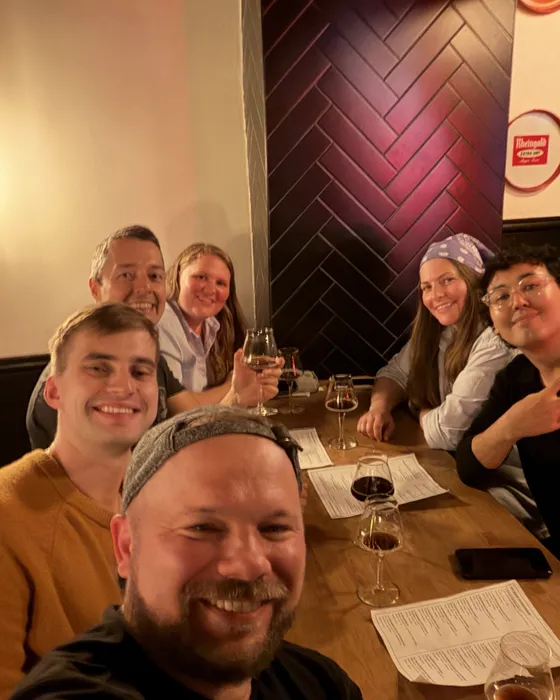 Six guests smiling around a Rounds table at New York Beer Dispensary