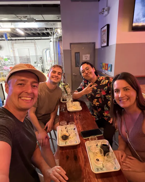 Four guests at a bar rail with flight trays at Other Half on Centre Street